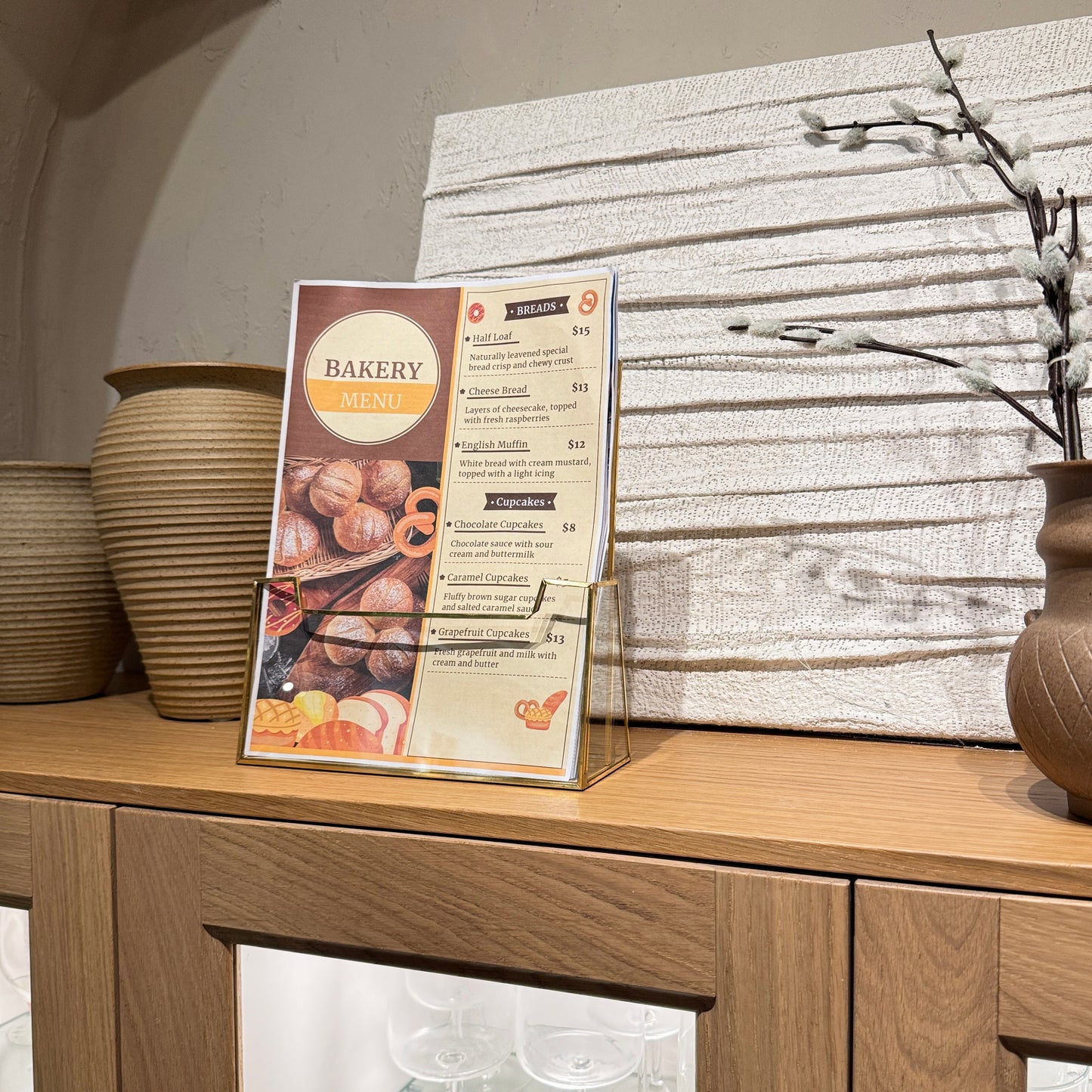 Clear glass brochure holder with sleek gold frame on countertop for menu restaurant hotel bakery 