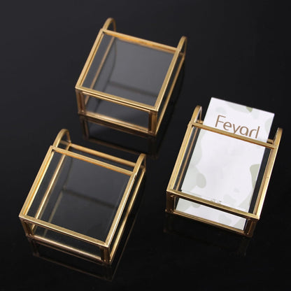 Three Gold Glass Business Card Holders lying on a desk, highlighting the clear glass structure and gold edge design