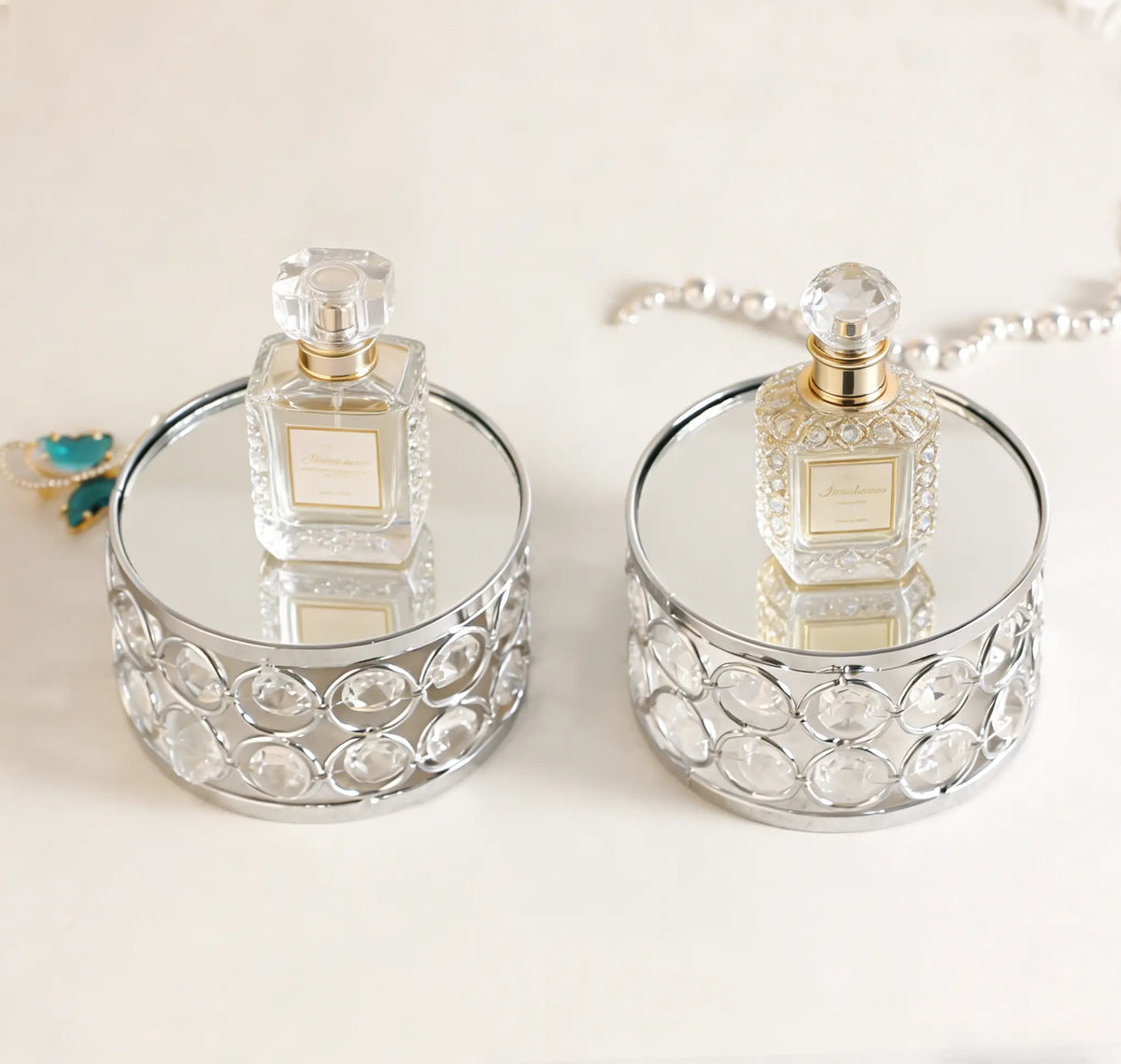 Elegant Silver Display Platform showcasing two perfume bottles with sparkling crystal details for a luxurious presentation
