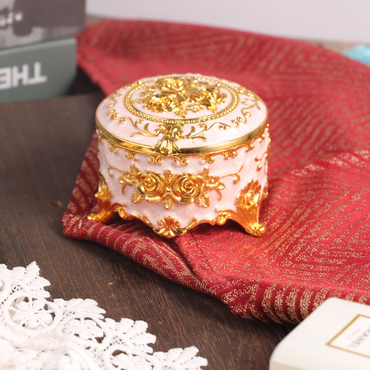Compact Soft Pink Jewelry Box placed on a tabletop showcasing its charming floral details and vintage style