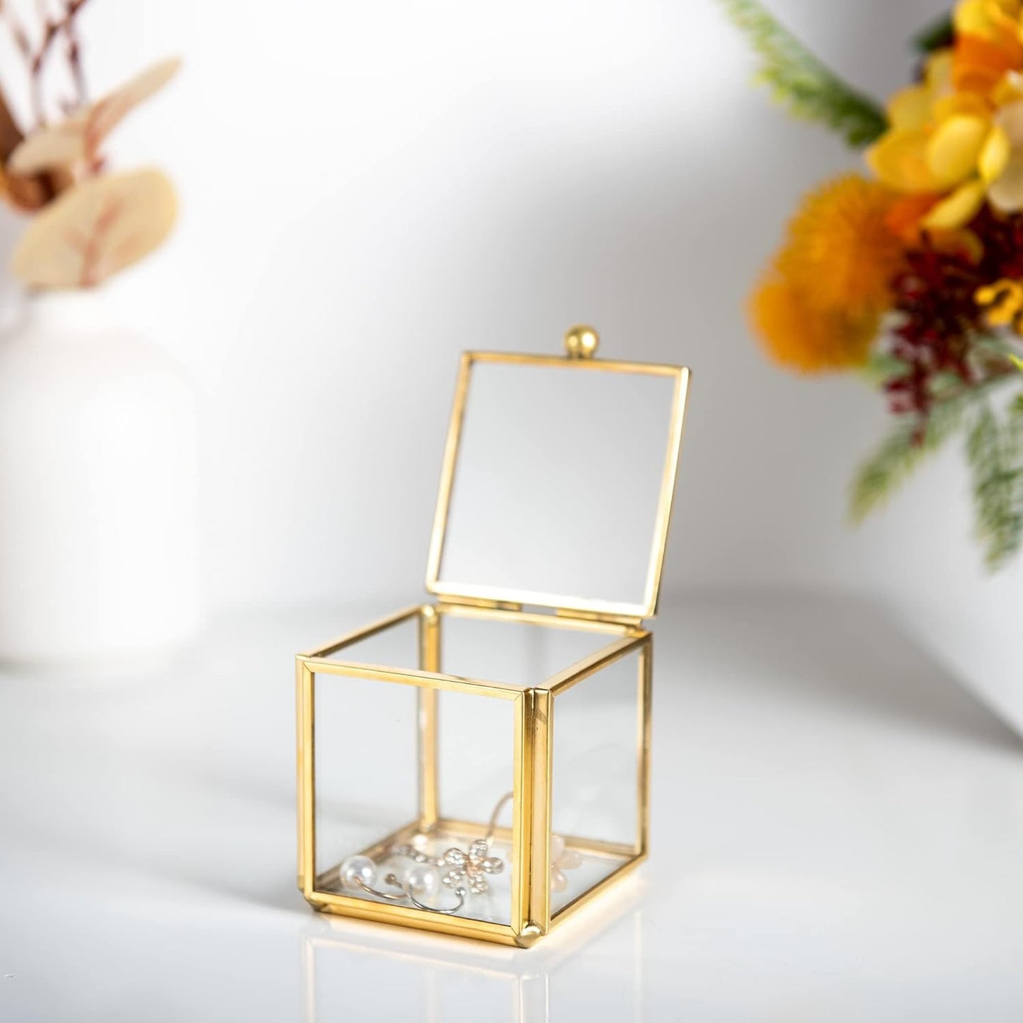 Small Gold Glass Jewelry Box organizing earrings on a tabletop for a neat and elegant display