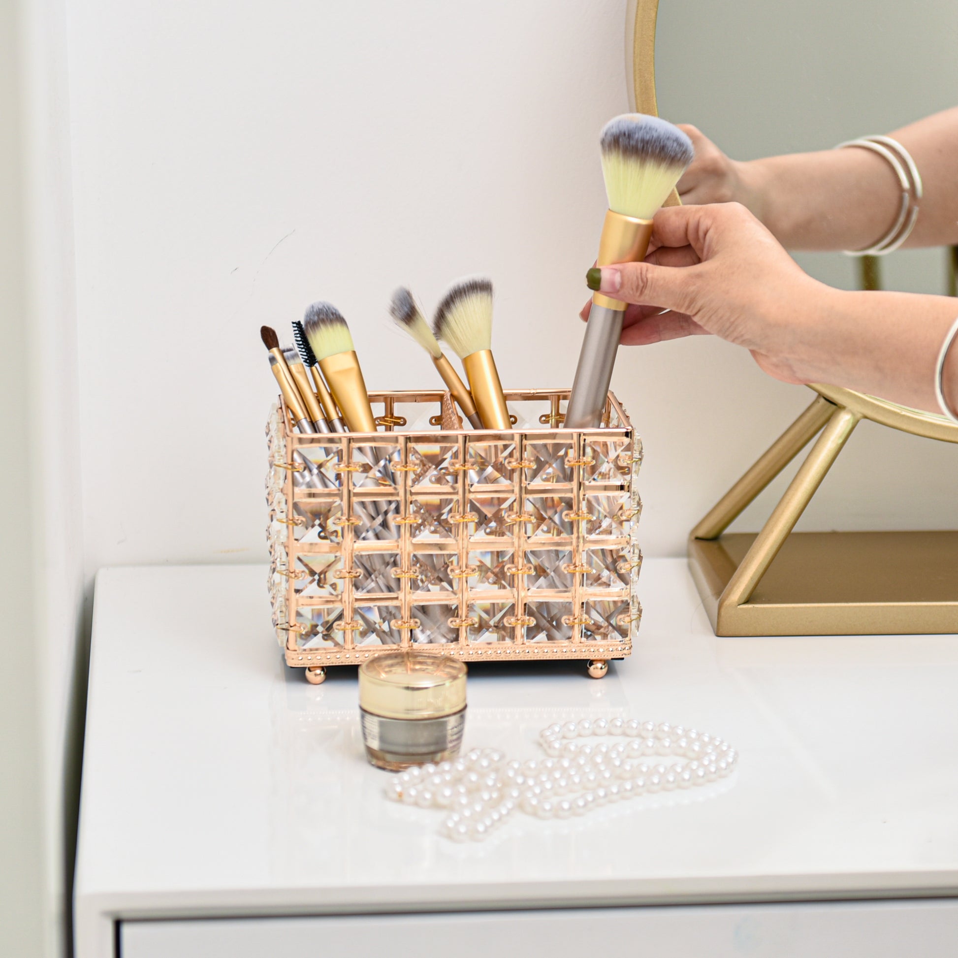 Gold Crystal Makeup Brush Holder on a vanity table with makeup brushes easily accessible for daily use