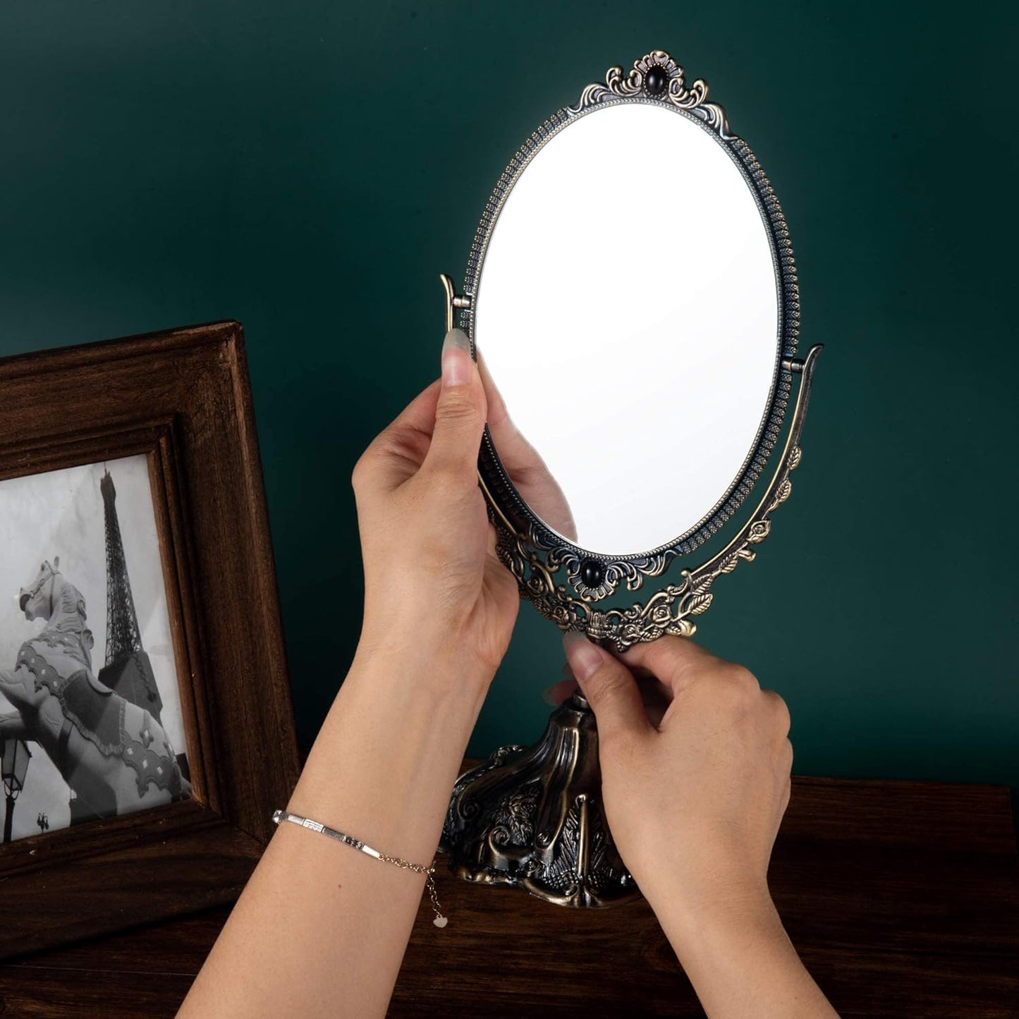 Elegant Vintage Vanity Mirror held with both hands showcasing its floral frame design and refined decorative details